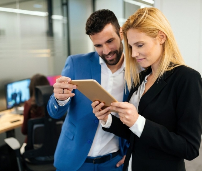businesspeople-discussing-while-using-digital-WFGVC3X@2x